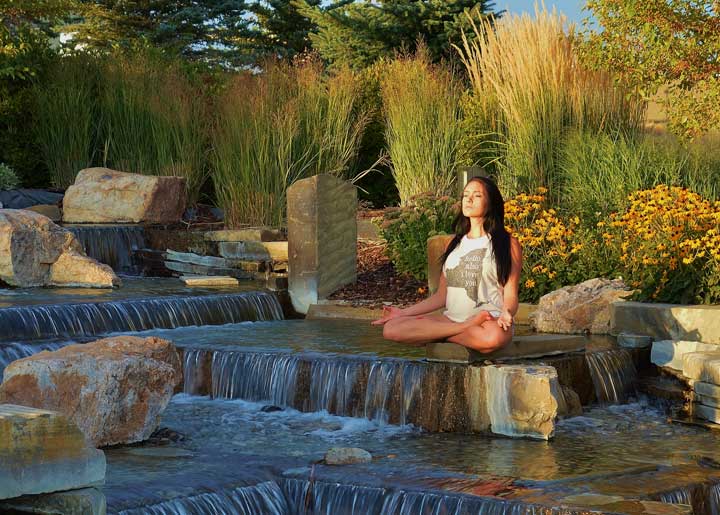 girl meditation near waterfall web